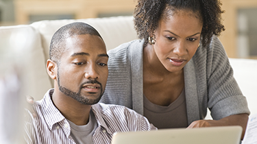 Man and woman looking at a laptop screen together 